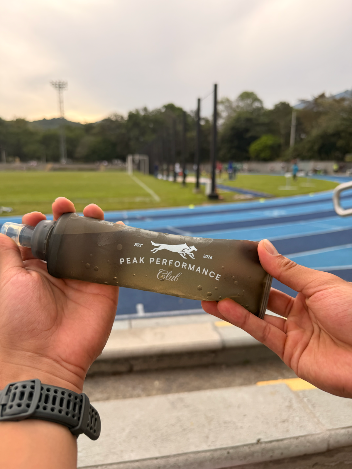 Bolsa de agua Peak Performance Club sostenida en la mano